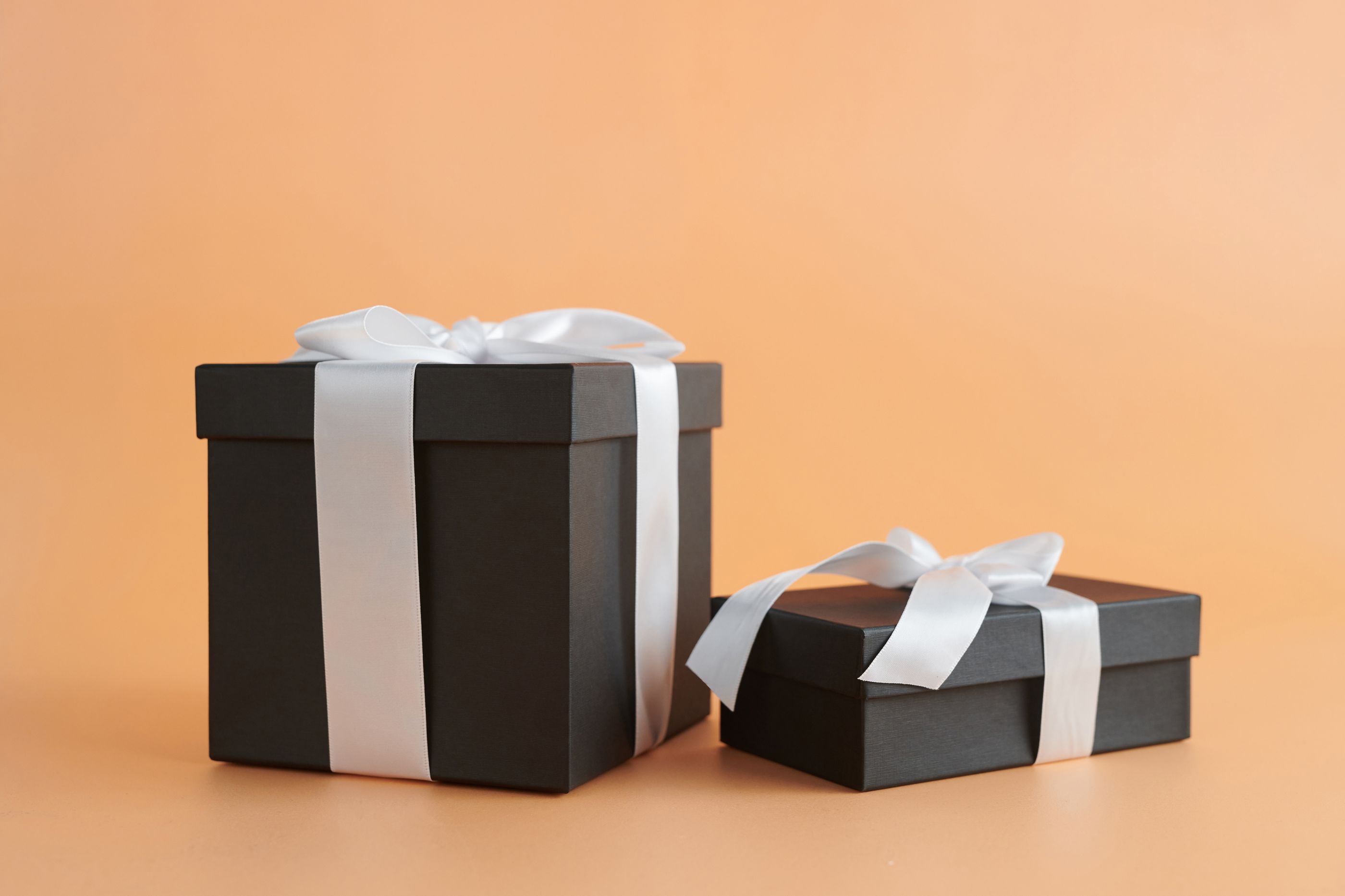 Dos cajas de regalo con lazo sobre fondo beige