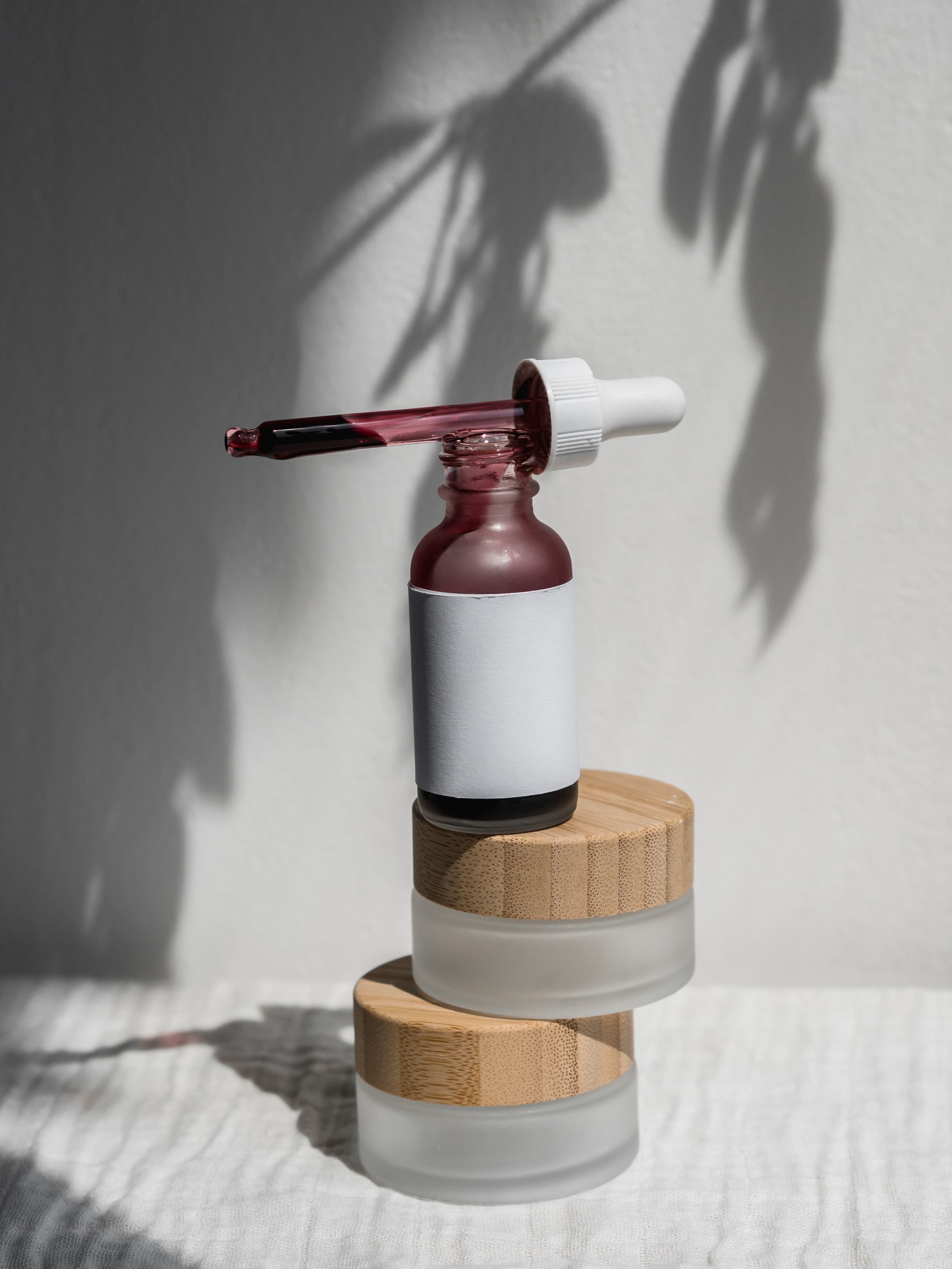 Frasco de cosmética con dosificador sobre fondo neutro